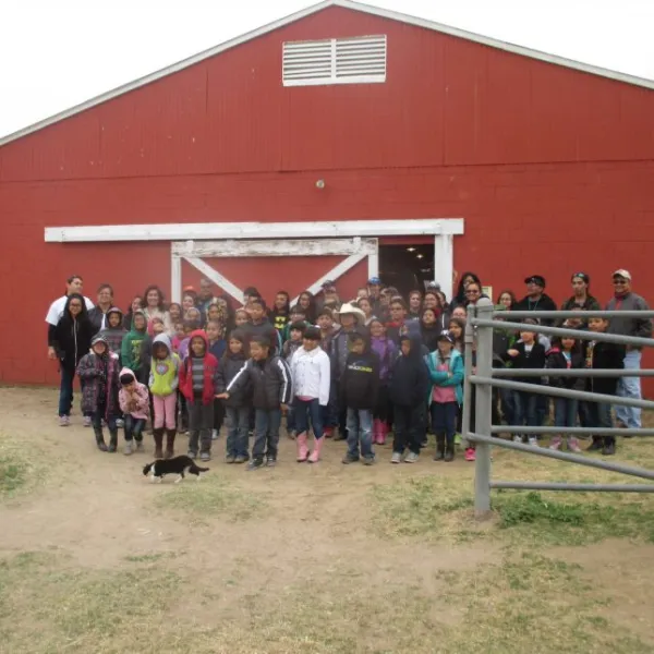 a group of people standing in front of a barn
